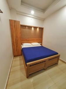 a bedroom with a bed with a wooden headboard at Stay Court - Business Class Hotel - Near Central Railway Station in Chennai