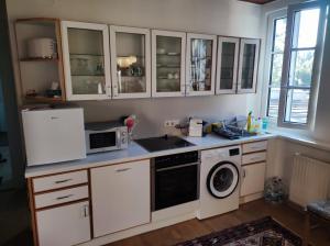 een keuken met witte kasten en een wasmachine en droger bij Zentrale Lage in Bad Ischl - Top 4 in Bad Ischl