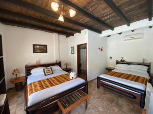a bedroom with two beds and a wooden ceiling at Hotel Puerto Gaviota in Tonsupa