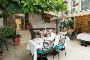 un restaurant avec des tables blanches et des personnes y assises dans l'établissement Makarun Heritage Rooms, à Split