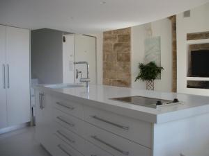 a white kitchen with a sink and a counter at The White House Jerusalem סוויטת הבית הלבן ירושלים in Jerusalem