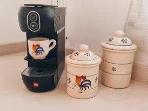 eine Kaffeemaschine und zwei Kaffeetassen auf der Theke in der Unterkunft Le Dimore di Thesia - La Piccinna - La Beddha in Otranto