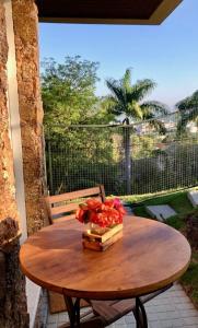 uma mesa de madeira com um ramo de flores numa varanda em Studios Altos da Igrejinha em Florianópolis