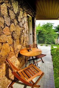 uma mesa e cadeiras num pátio com uma parede de pedra em Studios Altos da Igrejinha em Florianópolis