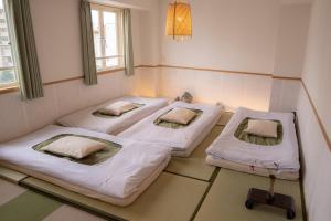 ein Krankenhauszimmer mit drei Betten darin in der Unterkunft 久Hisashi新栄店民泊 in Nagoya