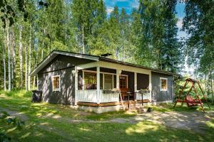 a small house in the woods with a swing at Koivuranta in Räätäniemi