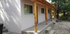 a building with a porch with a wooden roof at Cabaña La Camelia in Creel
