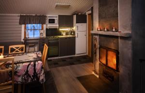 a kitchen with a fireplace and a kitchen with a stove at Koivuranta in Räätäniemi
