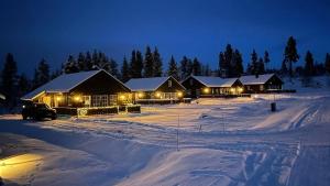 a row of lodges in the snow at night at Sanderstølen Hytte in Tisleidalen