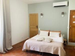 a bedroom with a bed with white sheets and pillows at Casa Cessenon in Cessenon