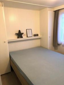 ein Schlafzimmer mit einem Bett und einem Stern auf einem Regal in der Unterkunft Sinne in Ballum