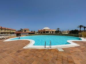 una piscina con dos tablas de surf en el medio. en AGPI Fuerteventura Apartments Internet Fibra WIFI GRATIS, en Costa Calma