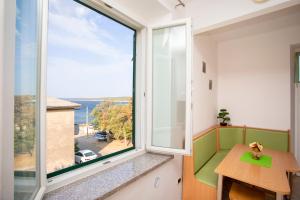 a room with a window with a table and a view at Apartman Lidija Koromačno in Koromačno