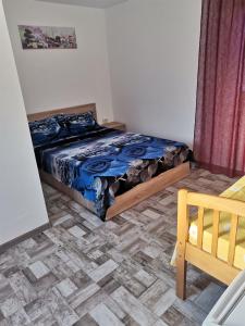 um quarto com uma cama e piso em madeira em Casa Andrei A em Corbu