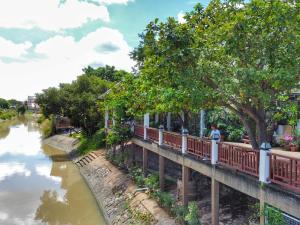 a man standing on a bridge next to a river at Romyen Cafe' Homestay in Phra Nakhon Si Ayutthaya