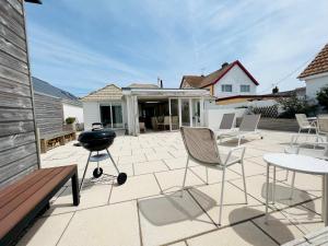 a patio with chairs and a barbecue grill on it at Pass the Keys Fabulous Beach Front Holiday Location in Lydd