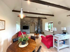 a living room with a table and a red couch at Pass the Keys Beautiful 2BR Converted Mill - Idyllic Location in Dumfries