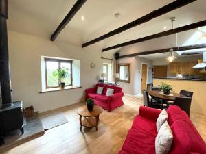 a living room with a red couch and a table at Pass the Keys Beautiful 2BR Converted Mill - Idyllic Location in Dumfries