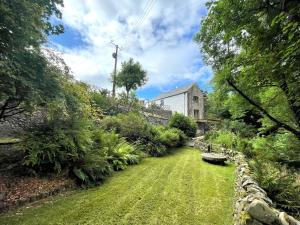 a garden with a green lawn and a building at Pass the Keys Beautiful 2BR Converted Mill - Idyllic Location in Dumfries