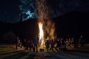 een groep mensen die 's nachts rond een groot vuur staan bij Aleu - Apuseni Mountains in Pietroasa