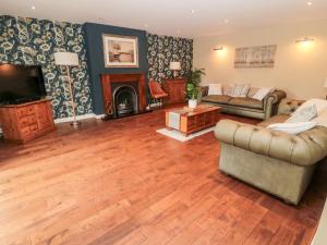 a living room with a couch and a tv and a fireplace at Calm Skies in Berwick-Upon-Tweed