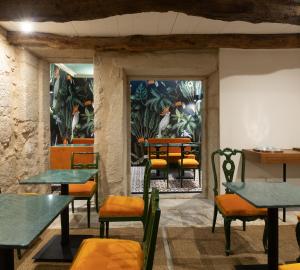 una habitación con mesas y sillas y una pared con plantas en Almadina Smart Luxury, en Oporto