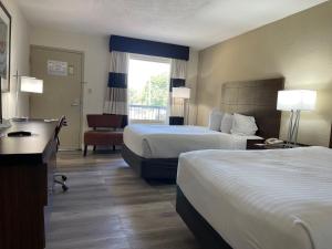 Habitación de hotel con 2 camas y escritorio en Remodeled, Huge Pool, Tiki Bar & Grill, Quiet Room, en Sarasota