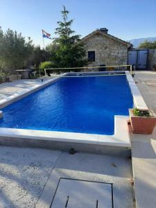 a large blue swimming pool sitting next to a house at Apartment Velebit with swimming pool - 10km from sea - 20km from Zadar in Benkovac