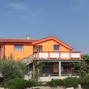 a large orange house with a balcony at Apartment Velebit with swimming pool - 10km from sea - 20km from Zadar in Benkovac