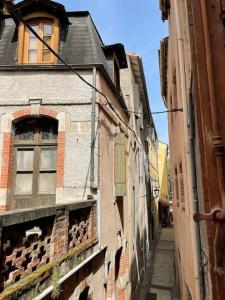 un callejón en una ciudad vieja con un edificio en Maison de ville dans le centre historique de Cahors - Cosy townhouse in the historical center of Cahors, en Cahors