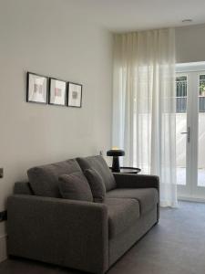 a living room with a couch and a window at Brand new 3-bedroom home in London in London