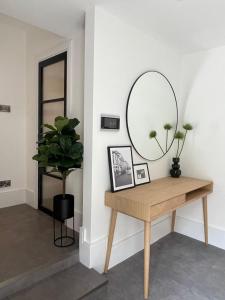 ロンドンにあるBrand new 3-bedroom home in Londonのテーブルと鏡付きの部屋