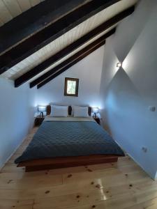 ein Schlafzimmer mit einem großen Bett im Dachgeschoss in der Unterkunft Fern Farm Eco Studio Apartment in Mojkovac