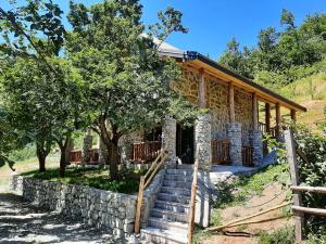 a stone house with stairs and a stone wall at Fern Farm Eco Studio Apartment in Mojkovac