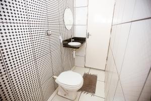 a white bathroom with a toilet and a sink at Hotel Barão Palace in Teresina