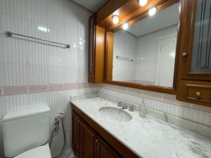 a bathroom with a sink and a toilet and a mirror at Apartamento a 100m da Rua Coberta in Gramado