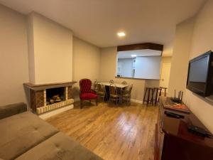 a living room with a couch and a fireplace at Apartamento a 100m da Rua Coberta in Gramado