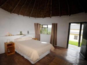 a bedroom with a bed and a large window at THE HAVEN HOTEL in Mpume