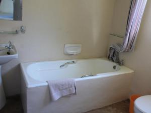 a white bath tub in a bathroom with a sink at THE HAVEN HOTEL in Mpume