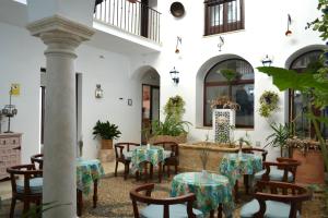 une cour avec des tables et des chaises dans un bâtiment dans l'établissement Hotel Marisa, à Cordoue