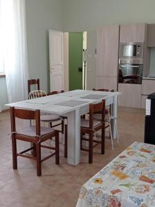 uma grande mesa branca e cadeiras numa cozinha em Rifugio escursionistico ex-scuola Grassi, Bubbio em Bubbio