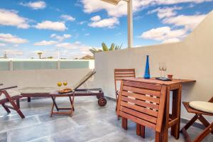 patio z drewnianym stołem i krzesłami oraz stołem sidx sidx w obiekcie Los Molinos Luxury y Relax w Costa Teguise