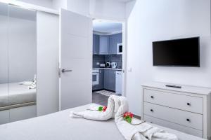 biała sypialnia z ręcznikami na łóżku z telewizorem w obiekcie Los Molinos Luxury y Relax w Costa Teguise