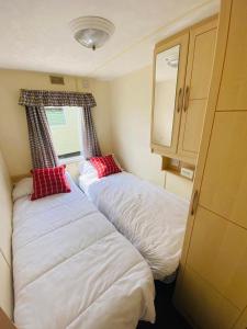 two beds in a small room with a window at 604 Seawick in Jaywick Sands