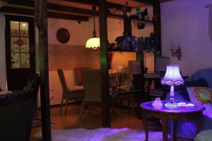 fioletowy pokój ze stołem i lampką w obiekcie budabu w mieście Sighnaghi