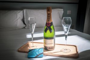 a bottle of champagne and two glasses on a table at Hotel Lilas Blanc in Paris