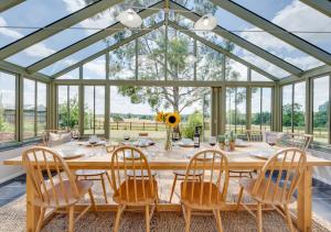 a dining room with a large wooden table and chairs at Fairstead in Spexhall