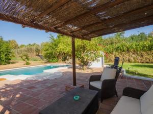 eine Terrasse mit einem Tisch und Stühlen neben einem Pool in der Unterkunft Cubo's Cortijo La Bolina in Cártama