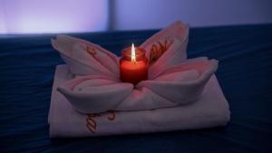 a candle sitting on top of a towel with a flower at Mariana Hotel Erbil in Erbil