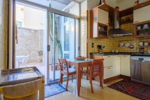 オートラントにあるCasa di Andreaのテーブルと椅子と窓のあるキッチン
